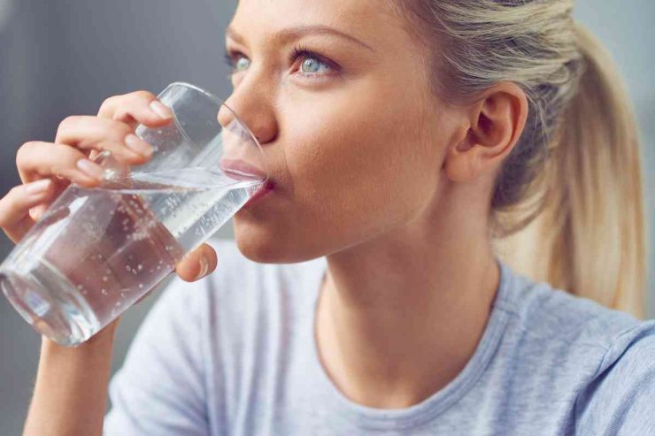 Ragazza beve un bicchiere di acqua