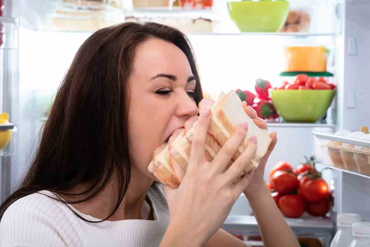 Ragazza mangia un grosso panino