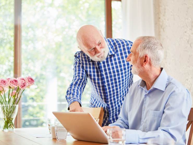 Due pensionati che parlano con il pc aperto