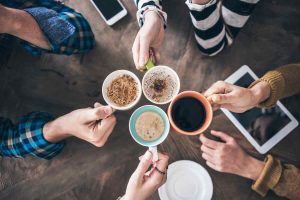 mani di persone con tazze di caffè di vario tipo