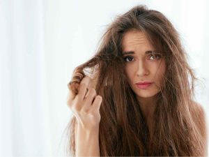 Ragazza affranta con capelli crespi e pieni di nodi