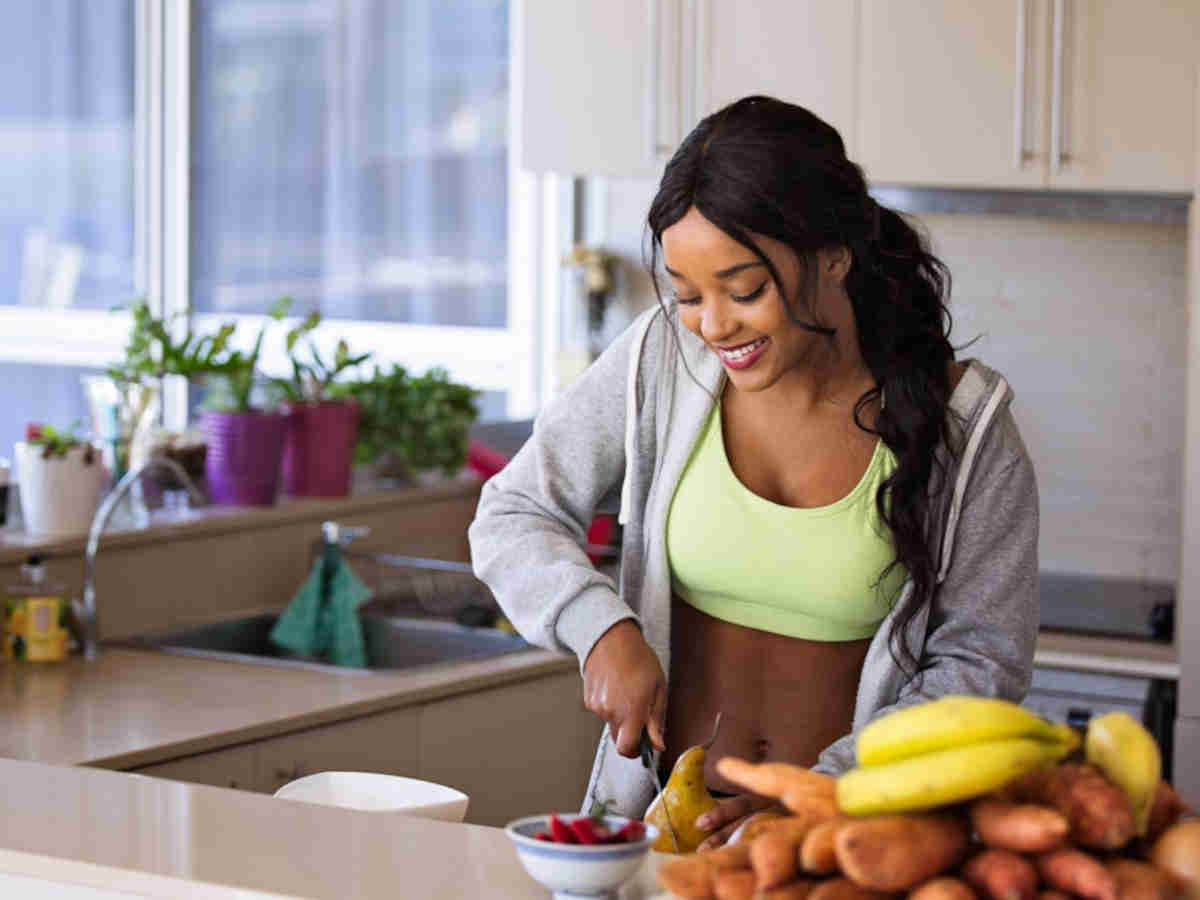 Ragazza che prepara la frutta in cucina