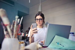 Ragazza al laptop e smartphone che lavora